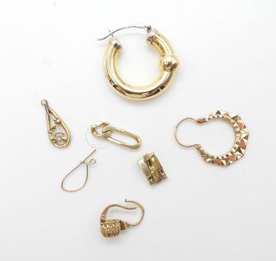 un assortiment de boucles d'oreilles et de bagues en or sur un fond blanc
