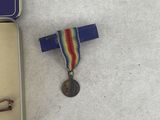 a small metal box with a medal and a medal on top of it