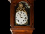 a wooden grandfather clock with roman numerals on the face