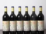six bouteilles de vin sont alignées sur une table en bois
