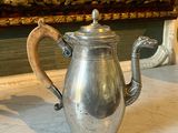 a silver coffee pot sitting on a marble counter