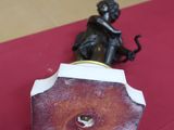 a figurine of a woman sitting on a red carpet