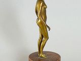 bronze statue of a woman standing on a marble base