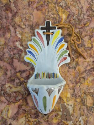 un petit vase orné d'une croix, posé sur une table