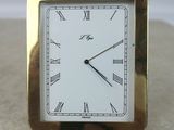 a small square clock with roman numerals on it
