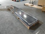une grande plaque de verre posée sur une palette dans un entrepôt