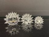 trois figurines de hérissons en cristal posées sur une table