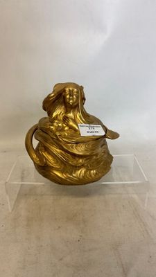 gold plated figurine of a woman holding a bowl