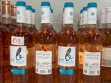 bottles of wine are lined up on a shelf in a refrigerator