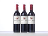 three bottles of red wine sitting on top of a table