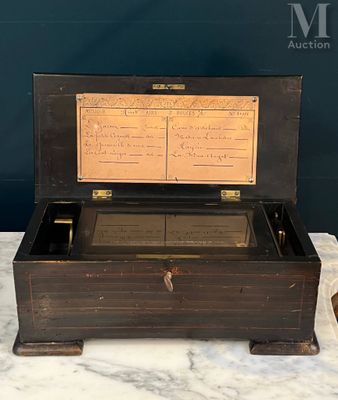 an old wooden box with music notes on it sitting on a marble table