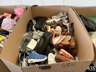 a cardboard box filled with shoes and other items