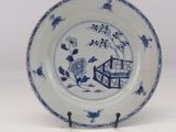 a blue and white plate with a bird and flowers on it