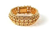 gold tone bracelet with a woven design on a white background
