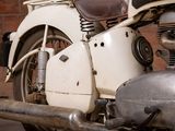 a white motorcycle parked in front of a brick wall