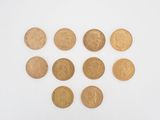 a close up of a group of gold coins on a white surface