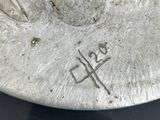 a close up of a silver plate with a bird on it