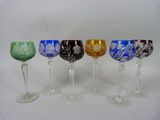 six wine glasses are lined up in a row on a white surface