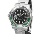 a close up of a wrist watch with a green bezel
