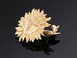 une image représentant une broche en forme de tournesol posée sur une surface noire