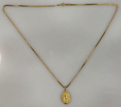 un collier plaqué or avec un pendentif représentant le visage de Jésus, monté sur une chaîne en or