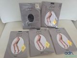 Quatre paires de bas moulants sont posées sur un canapé blanc.