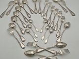 a lot of silver spoons and forks arranged in a circle