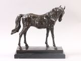 statue of a horse standing on a black base against a white background