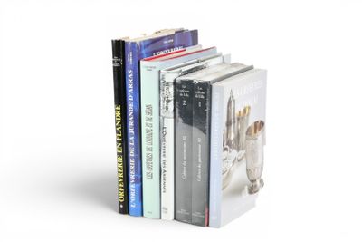 une pile de livres empilés les uns sur les autres sur une surface blanche