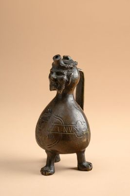 une vieille figurine en bronze représentant un oiseau avec une fleur sur la tête