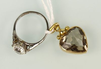 une image représentant une bague avec une pierre en forme de cœur, suspendue à un fil