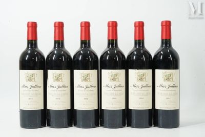 six bottles of red wine are lined up on a white surface