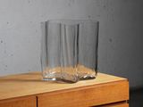 a glass on top of a wooden dresser next to a wall