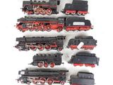 a lot of toy trains sitting on a white surface