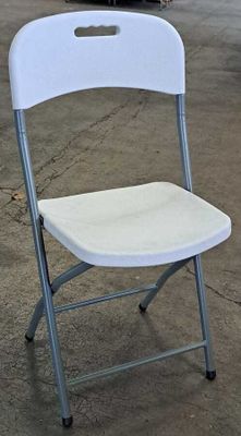a white folding chair sitting in a garage