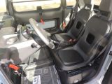 two seats in the back of a vehicle with a steering wheel