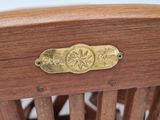 a wooden chair with a brass plate on the back of it