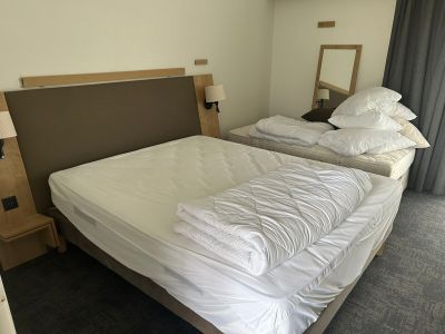 deux lits dans une chambre d'hôtel, recouverts de draps blancs