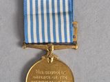an old medal with a blue and white ribbon on a table