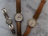 trois montres sont posées les unes à côté des autres sur une surface en marbre