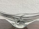 a glass bowl on a wooden table with a white wall in the background