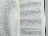 someone is reading a book on a table with a white background