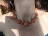 a woman wearing a necklace with red beads on it