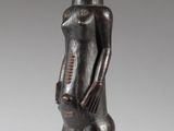 an image of a wooden statue of a man standing on a wooden base