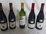 quatre bouteilles de vin sont alignées sur un drap blanc