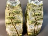 deux vases décorés d'arbres, posés sur une table