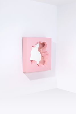 un tableau accroché au mur d'une pièce blanche aux murs roses
