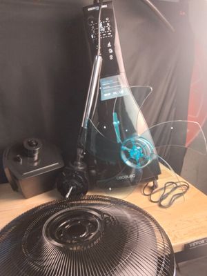 a bottle of wine sitting on a table next to a fan