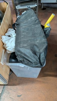a pile of trash sitting on the floor next to a trash can