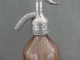 a brown glass bottle with a metal spout on it